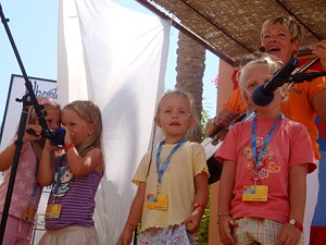 Karin sing mit vier
Kindern und spielt dabei Gitarre.