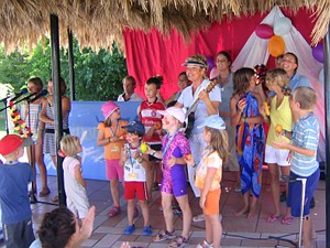 Karin Meier spielt Gitarre,
die Kinder befinden sich mit ihr auf der Bühne.