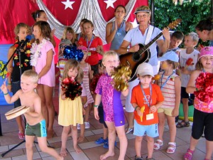 Karin Meier spielt Gitarre,
alle Kinder tanzen, singen und spielen Instrumente um sie herum auf der
Bühne.